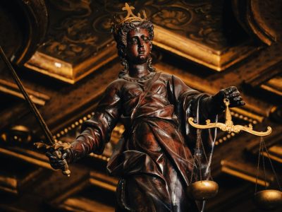 Detailed statue of Lady Justice holding scales and sword indoors with rich textures.